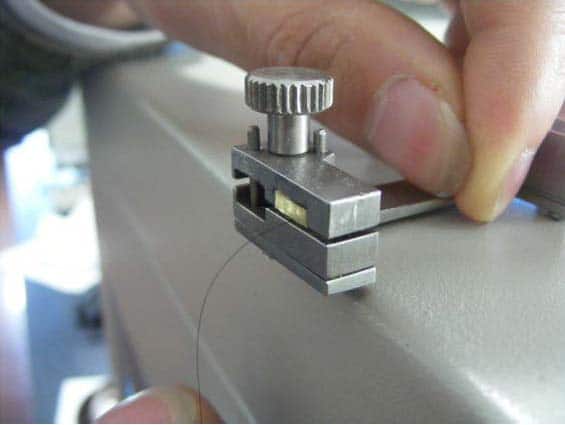 Place the specimen in upper clamp and tighten the screw